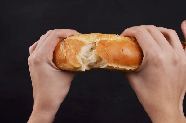Хлебный багет в руке на белом фоне — стоковое фото