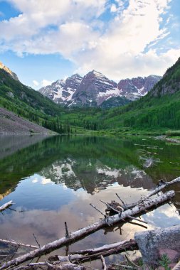 Sunset 'te Aspen Colorado' da kestane rengi çanlar. Güzel kestane rengi ve camdan yansıyan pembe bulutlar. Kayalıklar ve ağaçlar arasında çerçevelenmiş sudaki dağların yansıması