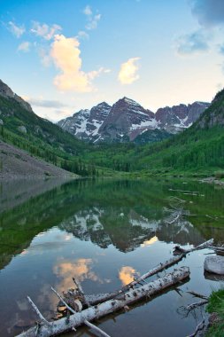 Sunset 'te Aspen Colorado' da kestane rengi çanlar. Güzel kestane rengi ve camdan yansıyan pembe bulutlar. Kayalıklar ve ağaçlar arasında çerçevelenmiş sudaki dağların yansıması