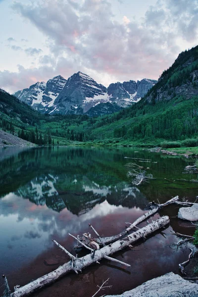 Sunset 'te Aspen Colorado' da kestane rengi çanlar. Güzel kestane rengi ve camdan yansıyan pembe bulutlar. Kayalıklar ve ağaçlar arasında çerçevelenmiş sudaki dağların yansıması