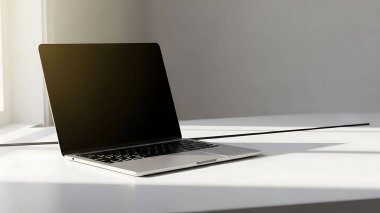 Minimalist gümüş dizüstü bilgisayar beyaz masada, parlak odada.