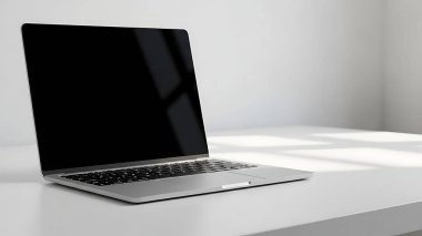 Minimalist tarzda beyaz yüzeyde modern gümüş dizüstü bilgisayar