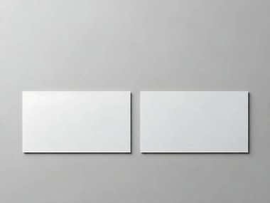 Açık gri arka planda yumuşak gölgeli iki beyaz kartvizit yerleştirilmiş..