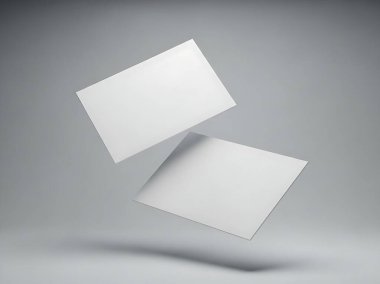Stüdyoda, yumuşak gri ışıklı ve ince gölgeli iki beyaz kart yüzüyor..