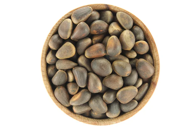 Pine nuts in a round wooden form — Stock Photo, Image