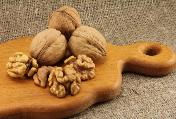 Nueces en una tabla de madera (tabla de cortar ) — Foto de Stock