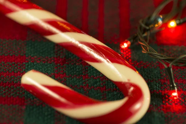 Candy Cane på en bakgrund av jul dukar och jul kransar — Stockfoto