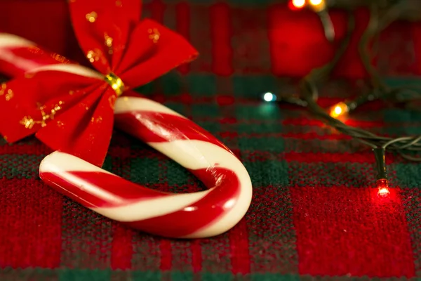 Candy Cane na tle świąteczne obrusy i Girlandy choinkowe — Zdjęcie stockowe