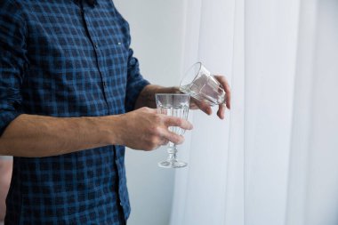 Adamın elinde boş şarap kadehleri var ve elleri vitiligo ile lekelenmiş..