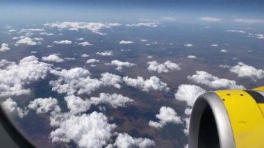 Uçak uçuşu. La Palma, Kanarya Adaları 'nda bulutların ve denizin üzerinde uçan bir uçağın kanadı. Uçağın penceresinden bak. 4K UHD
