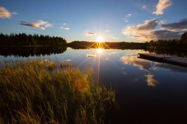 İsveç 'in kuzeyinde Laponya' da bir gölde sonbahar günbatımı.