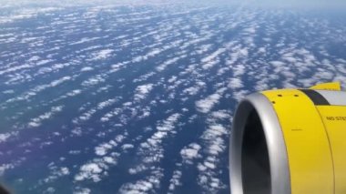 Uçak uçuşu. La Palma, Kanarya Adaları 'nda bulutların ve denizin üzerinde uçan bir uçağın kanadı. Uçağın penceresinden bak. 4K UHD