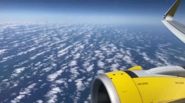 Uçak uçuşu. La Palma, Kanarya Adaları 'nda bulutların ve denizin üzerinde uçan bir uçağın kanadı. Uçağın penceresinden bak. 4K UHD