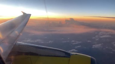 Uçak uçuşu. İspanya 'da bulutların ve denizin üzerinde uçan bir uçağın kanadı. Uçağın penceresinden bak. 4K UHD