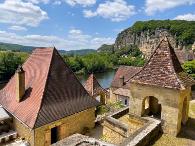 La Roque Gageac 'ta Dordogne nehrine bakan terasotta çatıları olan geleneksel evler, Fransa' nın Aquitaine kentindeki bir uçuruma karşı kurulmuş büyüleyici bir köy.