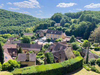 Fransa 'nın Dordogne kentindeki büyüleyici bir köy olan Castelnaud la Chapelle' in fotografik manzarası geleneksel mimari ve yemyeşil çevreleri vurguluyor.