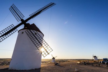Geleneksel İspanyol yel değirmeni bıçakları açık bir gökyüzünde gün batımında güneş patlaması yaratıyor.