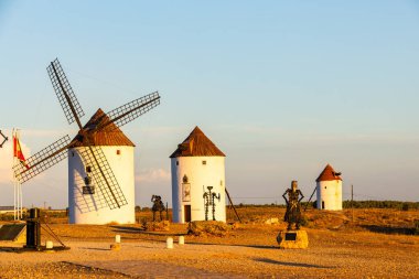 Geleneksel La Mancha yel değirmenleri açık bir gökyüzünün altında duruyor, İspanyol edebiyatını ve tarihini somutlaştırıyor.