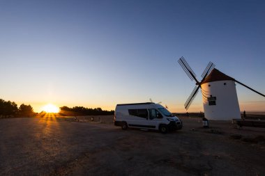 Kamp aracı gün batımında tarihi yel değirmenlerini keşfetmek için La Mancha bölgesinde seyahat ediyor.