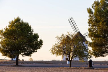 İspanya, Mota del Cuervo 'da gün batımında kırsal bir arazide duran yel değirmenleri