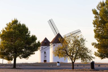 Geleneksel yel değirmenleri La Mancha 'nın kırsal manzarasını altın saatinde gösteriyor.