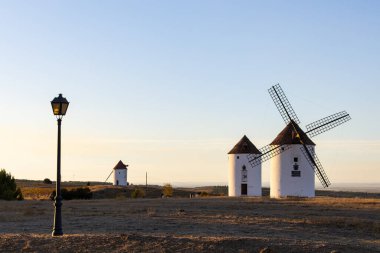 İspanyol yel değirmenleri ve kurak bir arazide bir sokak lambası tarihi manzarayı sunar.