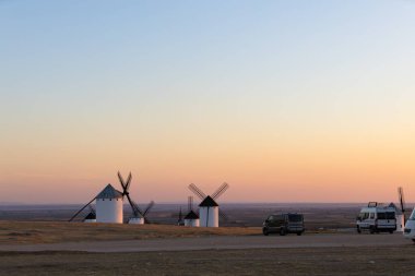 Bir tepede duran tarihi yel değirmenleri karavan parkında, akşam gökyüzünü yakalıyorlar.