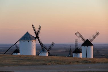 Geleneksel İspanyol yel değirmenleri bir tepede, sıcak bir öğleden sonra ışığında yıkandılar.