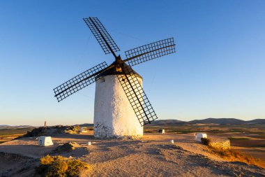 Gün batımında tepedeki tarihi yel değirmeni geleneksel İspanya ve Don Kişot 'u sembolize ediyor.