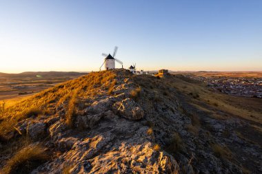 Beyaz yel değirmenleri ve İspanya 'nın Consuegra kasabasına bakan bir tepenin üzerinde duran antik şato.