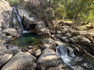 Şelale, granit kayaların üzerinden Katalonya, İspanya 'da el değmemiş bir doğal havuza dökülüyor.