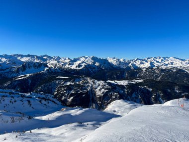 Kar, açık mavi gökyüzünün altındaki Pireneler dağlarını kapladı. Naut Aran, İspanya 'da bir kayak merkezi manzarası.