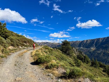 Sırt çantasıyla dağ yolunda yürüyüş yapan Pireneler 'de açık hava macerasının tadını çıkaran biri.