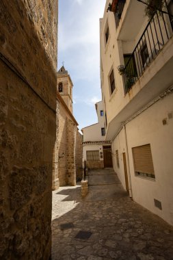Geleneksel mimari ve İspanyol köyünde kilise çan kulesi olan dar bir sokak.