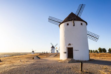 La Mancha kırsalındaki bir tepede duran bir grup eski yel değirmeni.