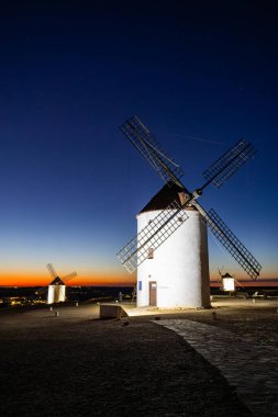 Geleneksel İspanyol yel değirmenleri Mota del Cuervo 'da canlı bir alacakaranlık gökyüzüne karşı aydınlandı
