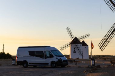 Kamp minibüsü, La Mancha 'nın ikonik beyaz yel değirmenlerine hayranlıkla bakıyordu.