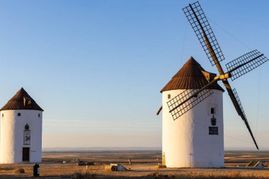 İspanyol yel değirmenleri berrak bir gökyüzünün altında duruyor, La Mancha kültürünü ve tarihini temsil ediyorlar.