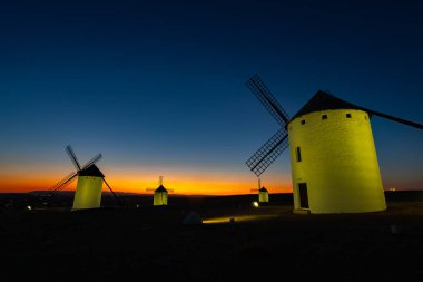 Yel değirmenleri alacakaranlıkta aydınlanır ve İspanya 'nın La Mancha şehrinde ünlü bir manzara yaratır.