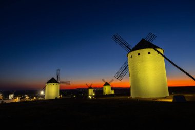 La Mancha 'daki geleneksel İspanyol yel değirmenleri alacakaranlıkta aydınlandı ve mistik bir manzara yarattı.