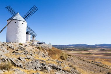 İspanya, Consuegra 'da geleneksel yel değirmenleri, geniş bir kırsal alana sahip güneşli bir günde