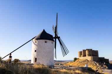 İspanya, Consuegra 'da tarihi bir şatosu olan bir tepede duran geleneksel yel değirmeni.
