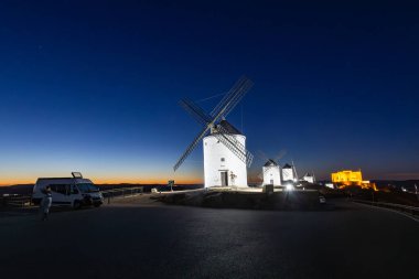 Consuegra yel değirmenleri alacakaranlıkta parlıyor, tarihi bir seyahat ve macera deneyimi sunuyorlar.