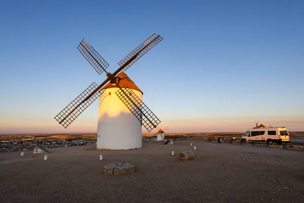Kasabanın ve tarihi yel değirmenlerinin yakınındaki tepede park etmiş karavan La Mancha 'da günbatımını yaşıyor.