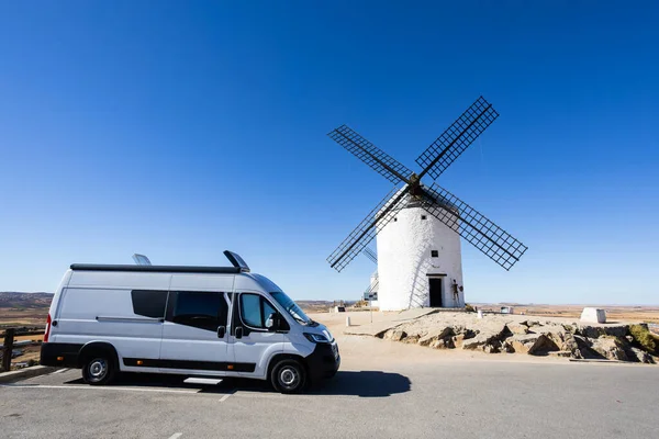 Consuegra 'da güneşli bir günde geleneksel yel değirmenine hayran olan bir karavan park etti.