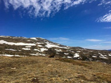 Pireneler yüksek dağlar bahar manzarasını karlı ve kuru otlarla gösteriyor.