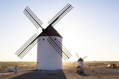 Mota del Cuervo, İspanya; 21 Eylül 2025: İspanya 'nın La Mancha kentinde günbatımına karşı duran geleneksel yel değirmenleri