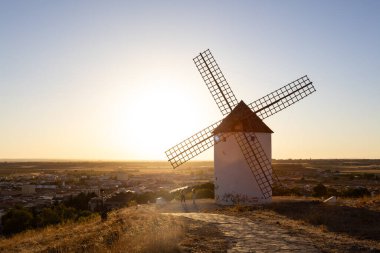 Mota del Cuervo, İspanya; 21 Eylül 2025: Castilla La Mancha 'da gün batımına bakan bir kasabada duran yel değirmeni