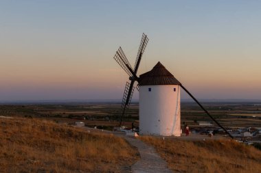 Mota del Cuervo, İspanya; 21 Eylül 2025: Geleneksel İspanyol yel değirmeni Mota del Cuervo 'da sıcak bir günbatımında duruyor