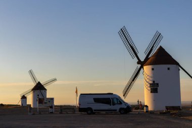 Mota del Cuervo, İspanya; 22 Eylül 2025: Kamp aracı İspanya 'nın Mota del Cuervo kentinde tarihi yel değirmenlerinin yakınına park etmiş ve günbatımının keyfini çıkarıyordu.
